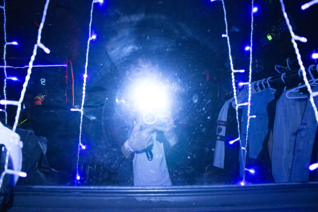 The author of the blog in a mirror with a very bright flash of light obscuring their face.