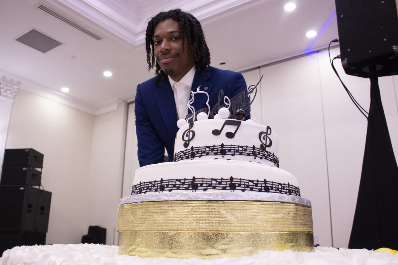 Jordan Steele, standing over the birthday cake of the gala